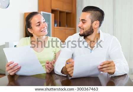 Happy smiling couple discussing financial contract details indoors
