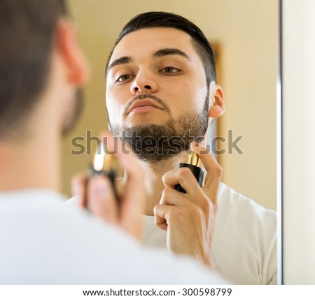 portrait handsome man applying perfume for keeping fresh