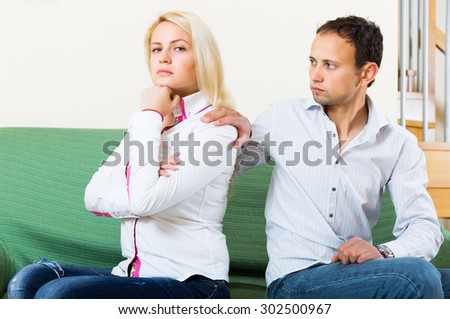 Family quarrel. Sadness man against sad young woman at home