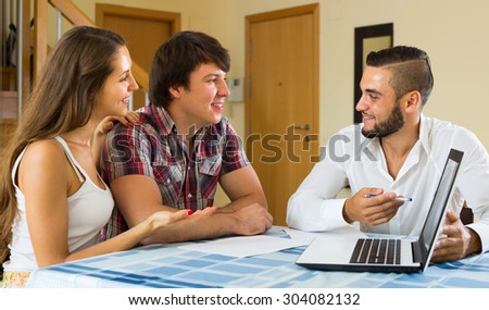 Young happy salesman try hard to sign a contract with man and woman