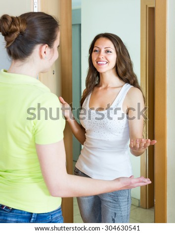 Happy smiling girl meeting girlfriend at the door