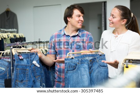 Man and woman choosing denim in an outlet shop