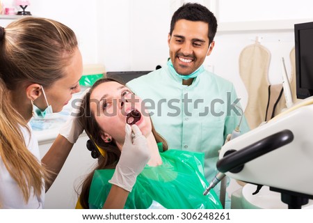 beautiful adult woman patient  treats teeth in the dental clinic. Focus on the patient