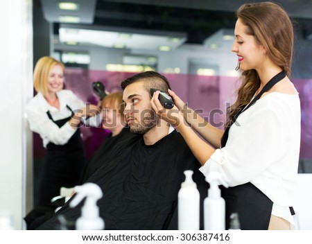 Adult man cuts hair at the hair salon. Focus on the man
