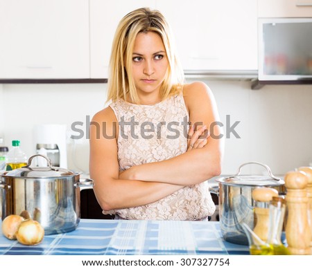Confused young housewife thinking what to prepare for dinner