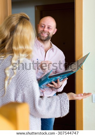 Smiling guy conducting  survey among people at door