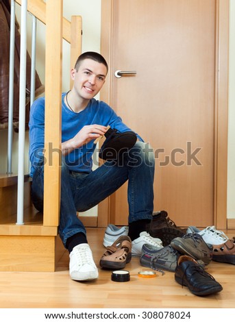 Young man woman cleaning shoes at home