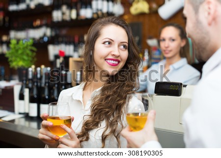 Young happy restaurant visitors waiting for table and drinking wine at bar