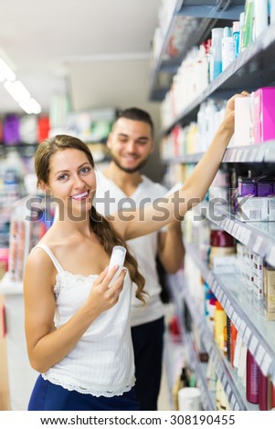 Woman in good spirits selecting cosmetical cream in the store