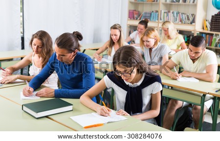 Group of adult pupils studying together in classroom