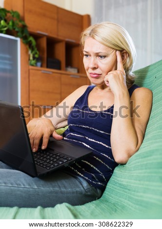 Sad senior lady receiving bad news in internet
