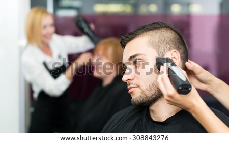 Beautiful man cuts hair at the hair salon