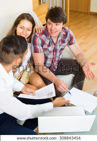 Young happy agent try hard to sign a contract with couple