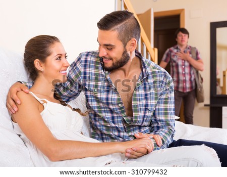 Surprised adult discovering his cheating attractive young wife at home