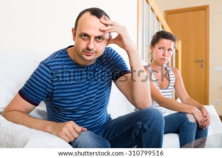 Ordinary american family couple shouting while arguing indoors