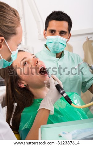 Girl diagnosing her teeth on photographic equipment at clinic