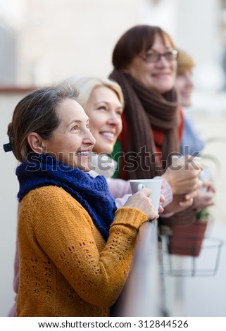 Group of senior female friends drinking tea at balcony