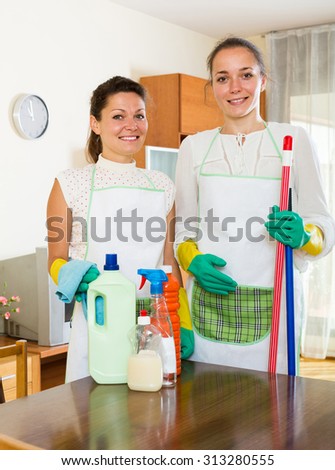 Two happy spanish cleaners cleaning room together