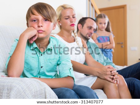 Sad tired parents and two kids in bad conflict at home