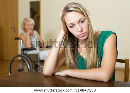 Communication problems between old woman in wheelchair and female daughter