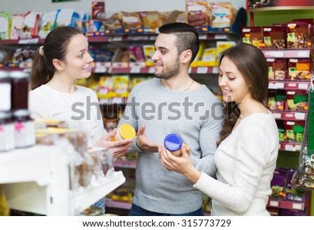 Happy adults people choosing tinned food at supermarket