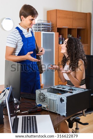 Technical engineer upgrading hardware of smiling spanish client computer indoors