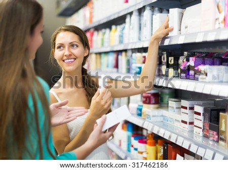 Happy girl in good spirits selecting cosmetical cream in the store