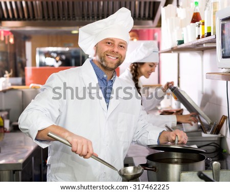 Positive  professional chefs working at take-away restaurant kitchen