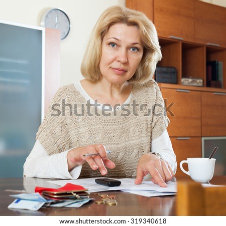 Wistful mature woman thinking about the financial issue at  home