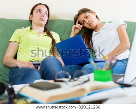 Dreary teenage student girls study in home with a books and computers