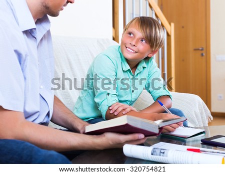 Happy teenager having private lesson with school teacher in living room at home