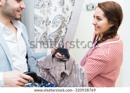 Positive young couple standing at boutique changing cubicle