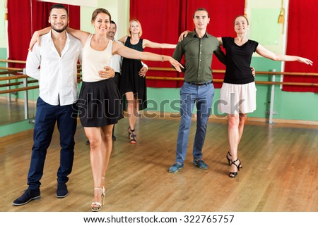 Young  smiling people dancing waltz in the hall