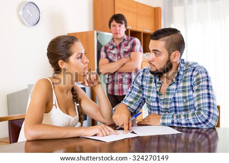 Two serious men and girl near desk with official papers