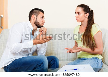 Upset nervous pair discussing problems with contract at home