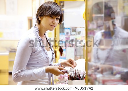young woman chooses the cosmetic  at cosmetics  shop