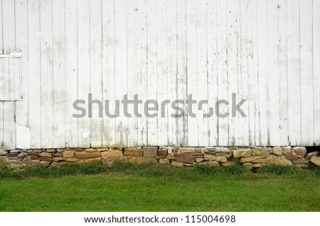 white weathered wall with stone foundation