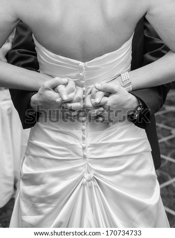 Bride and Groom interlocked fingers behind back