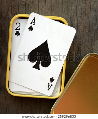 Ace of spades in box on wooden table background