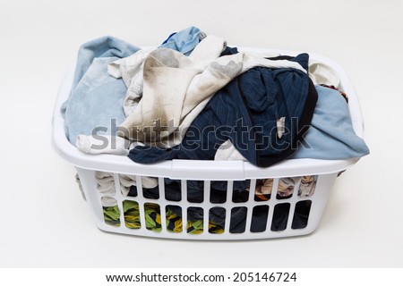 A basket full of dirty laundry with two dirty socks on top