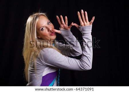 Informal blonde with casual emotions and gestures posing on the black backdrop