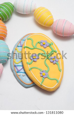 Easter Cookies in the Shape of an Egg Decorated with Blue and Yellow Frosting With Egg Glitter Garland