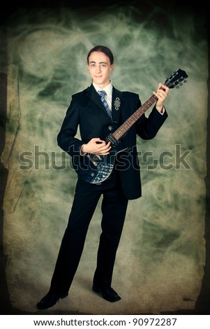 Young formal man playing on a guitar
