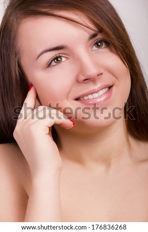 Natural portrait of a beautiful young woman with brown straight hair and clean skin without makeup