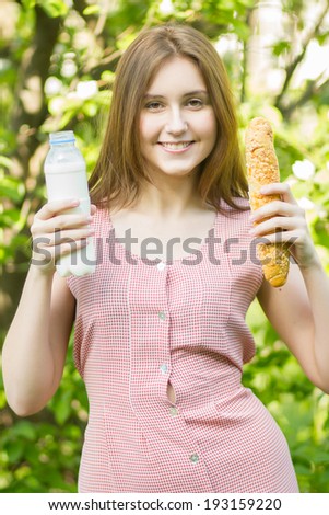 Portrait of a beautiful young woman with brown hair in retro dress on nature  The woman gathered her basket on picnic