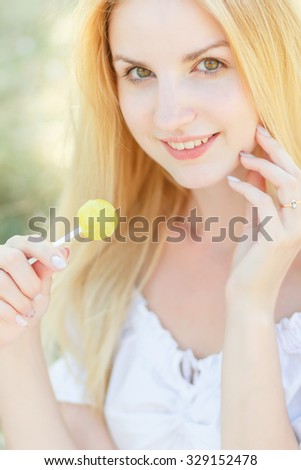 Young sexy woman sucking lollipop. Urban style. Outdoors, lifestyle. Soft focus