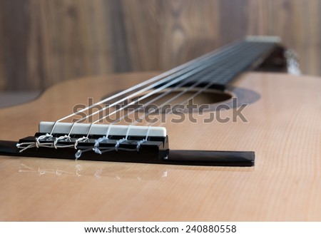 acoustic six-string guitar on the background of wooden panels