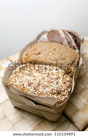 three types of bread, bread with caraway seeds, rye bread, bread with spices in a package with a bow on a wicker table