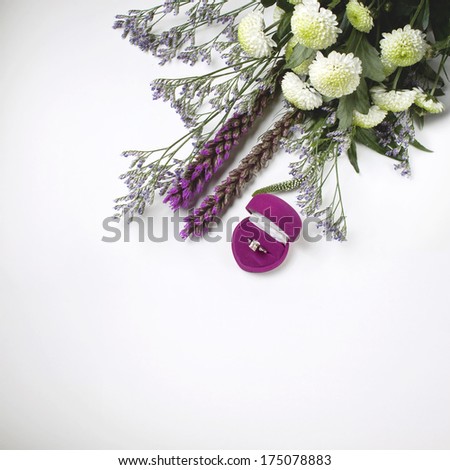 wedding ring in a pink box with the offer of a hand and heart and violet bouquet of field flowers and chrysanthemums