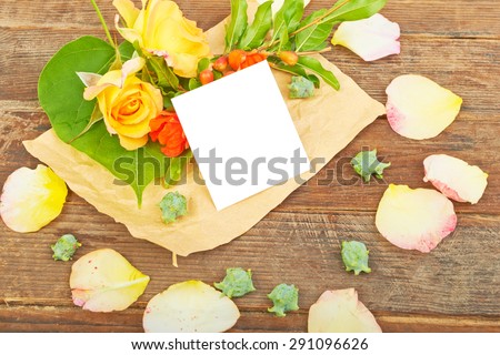 Flowers yellow roses leaves and flowers of pomegranate on a wooden background
